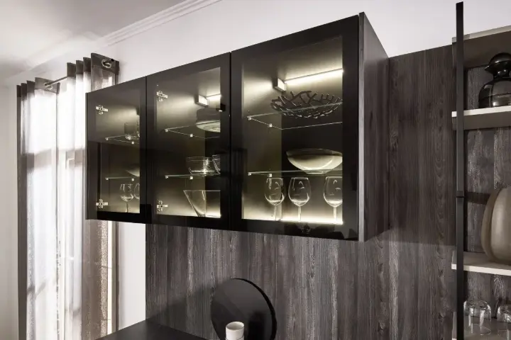 Beleuchtete Glasvitrine mit Gläsern und Geschirr in moderner Landhausküche.