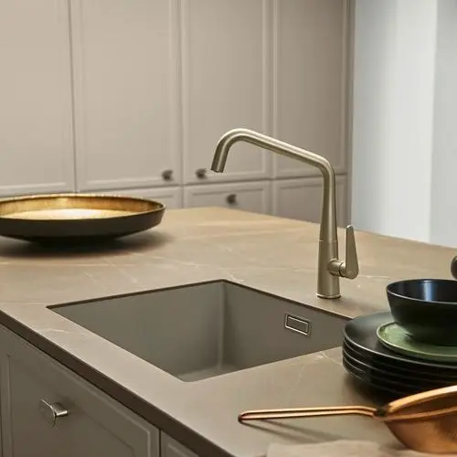 Flächenbündig integrierte Spüle in warmtoniger Arbeitsplatte mit schlichter Armatur – nahtloses Küchendesign