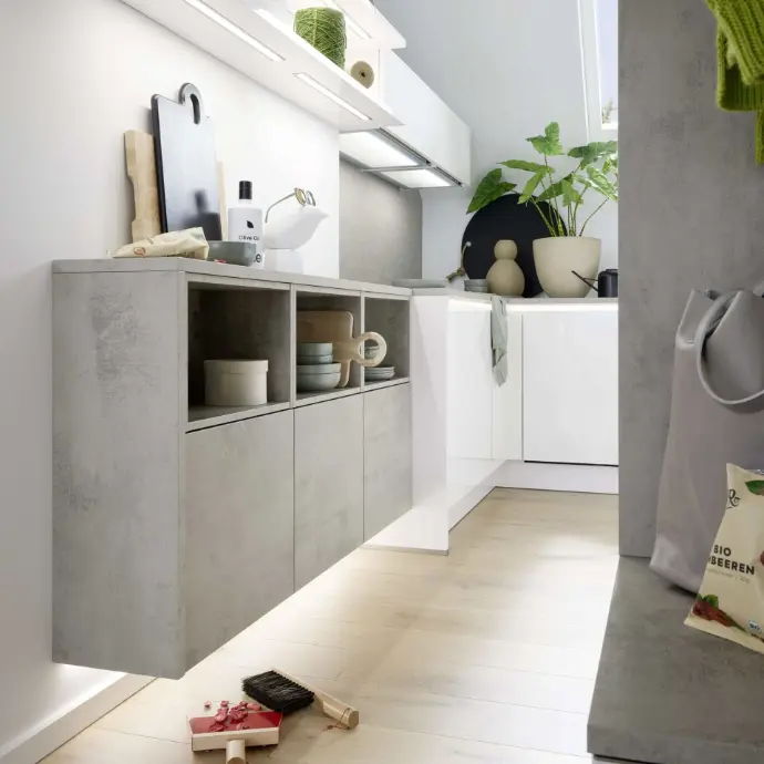 Schwebendes Sideboard in Betonoptik mit offenen Fächern und LED-Beleuchtung in einem hellen, modernen Wohn- und Küchenbereich