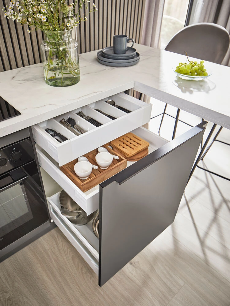 Eine gut geplante Schublade ist wie ein stiller Held im Alltag. Hier: zwei Ebenen, null Chaos, alles griffbereit. Wohnküchen-Stauraum: Schublade mit Besteckeinsatz und Doppelebene, Marmor-Arbeitsplatte, grifflose Fronten